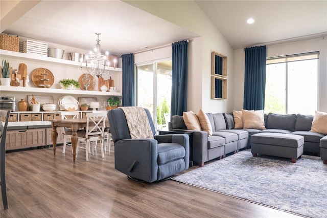 living room featuring lofted ceiling, recessed lighting, wood finished floors, and a notable chandelier
