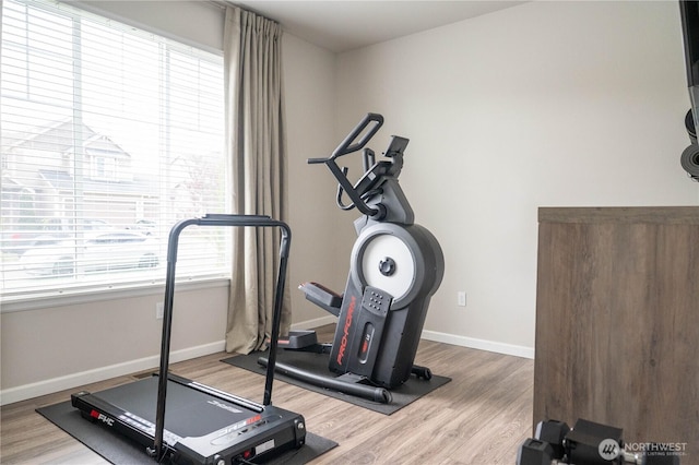 workout room with baseboards and wood finished floors