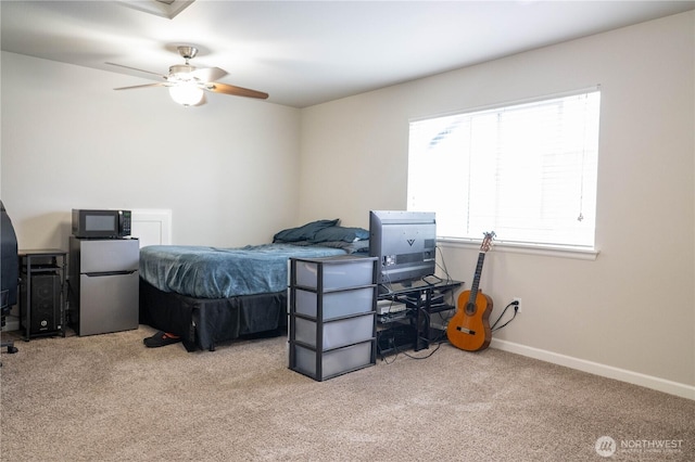 bedroom with freestanding refrigerator, baseboards, ceiling fan, and carpet
