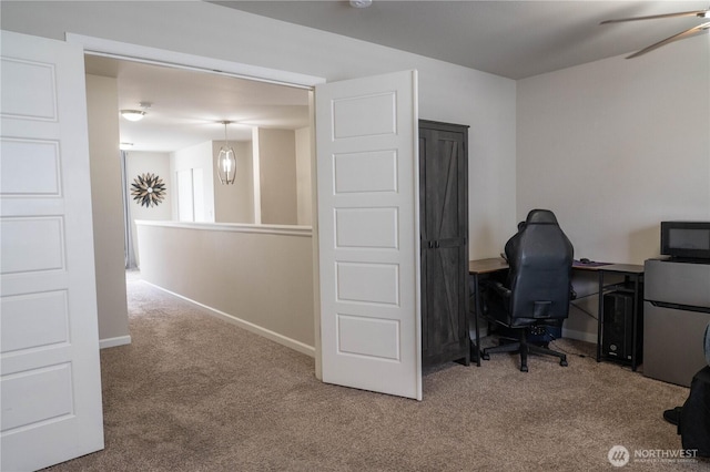 office space with carpet floors, a ceiling fan, and baseboards