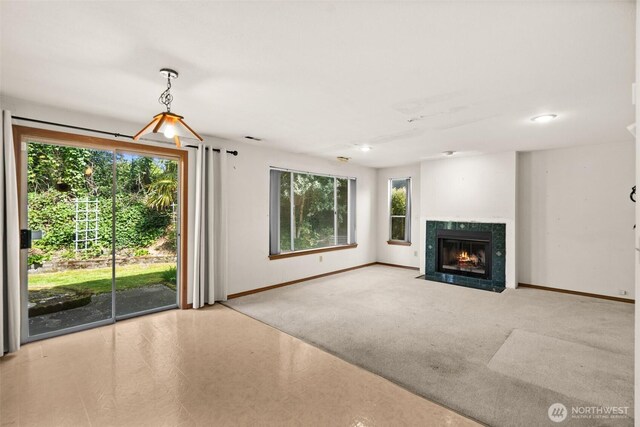 unfurnished living room featuring baseboards and a fireplace with flush hearth