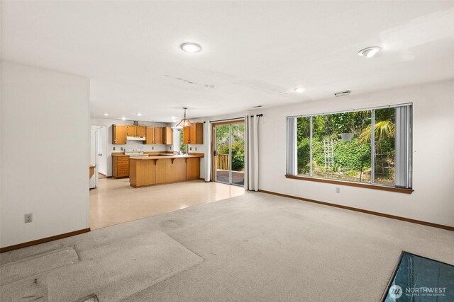unfurnished living room with baseboards, recessed lighting, and light colored carpet