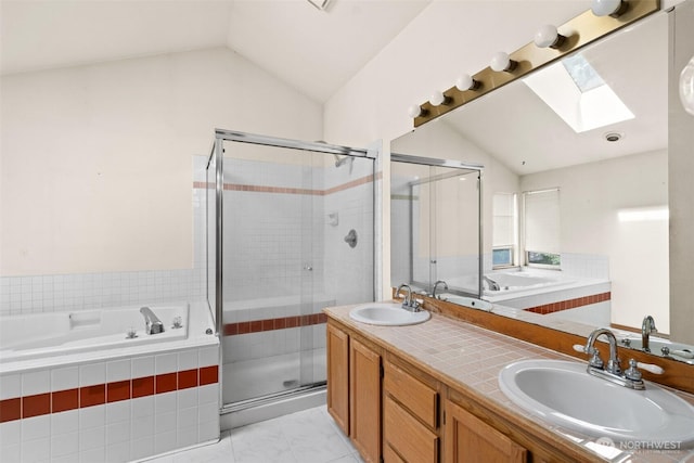bathroom featuring a sink, vaulted ceiling with skylight, and a stall shower