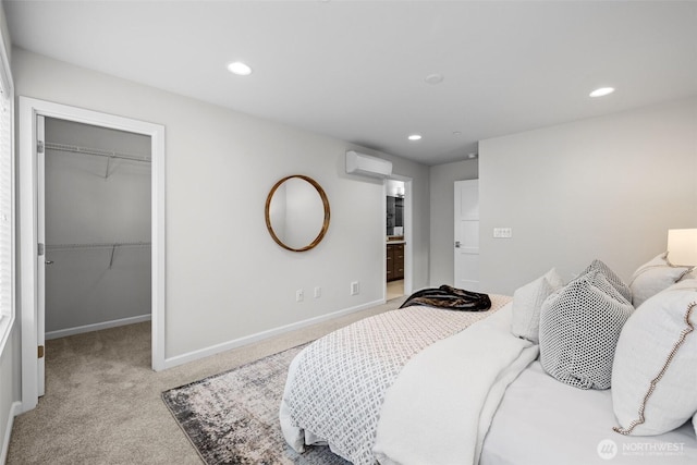 bedroom with light colored carpet, a wall mounted air conditioner, a spacious closet, and recessed lighting