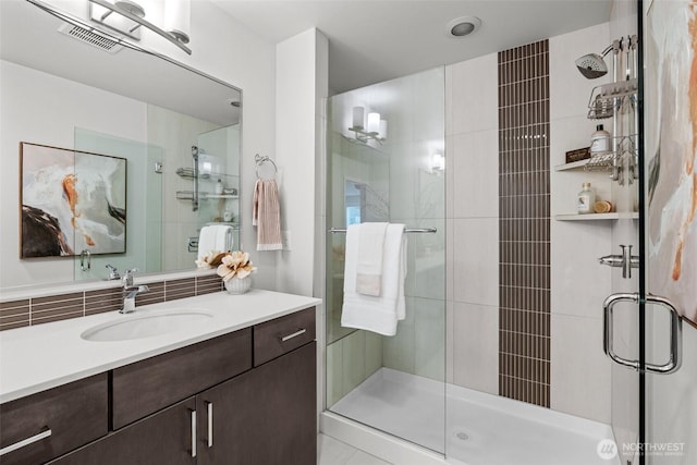 bathroom with vanity, visible vents, and a shower stall