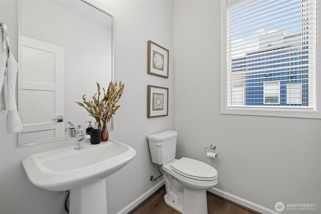 bathroom with a sink, baseboards, toilet, and wood finished floors