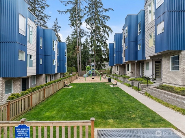 surrounding community with fence, a yard, and playground community