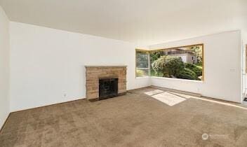 unfurnished living room featuring carpet flooring and a fireplace
