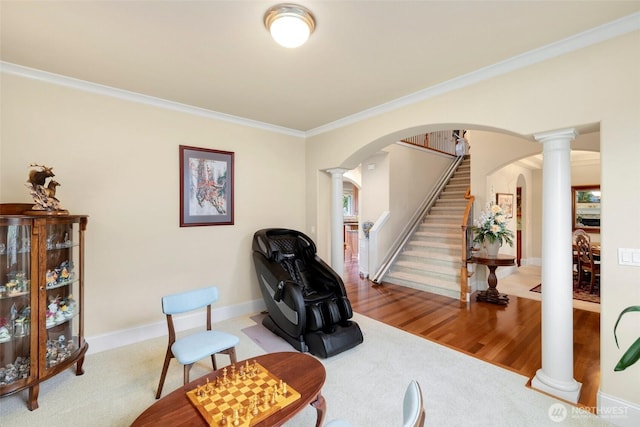 living area featuring arched walkways, decorative columns, stairs, and ornamental molding