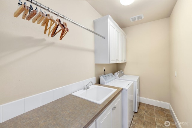 laundry area with cabinet space, a sink, separate washer and dryer, baseboards, and visible vents