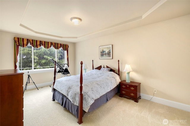bedroom with baseboards, carpet floors, and a tray ceiling