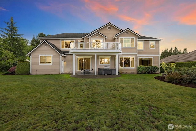 rear view of property with a lawn, a patio area, and a balcony