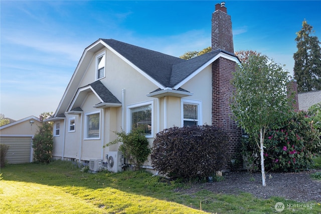 view of home's exterior with a chimney, roof with shingles, a lawn, ac unit, and stucco siding