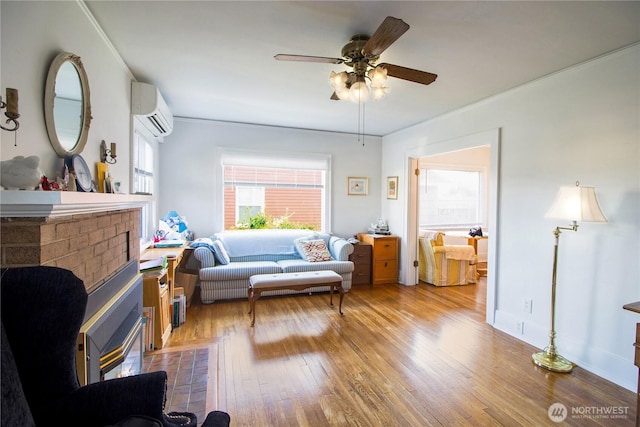 bedroom featuring light wood-style floors, ceiling fan, a wall mounted AC, and ornamental molding