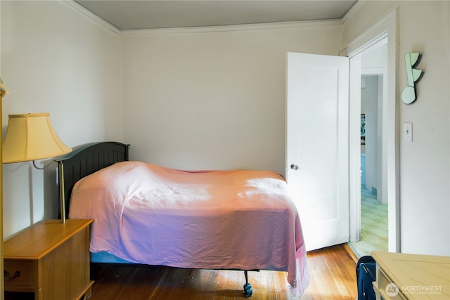 bedroom featuring crown molding and wood-type flooring