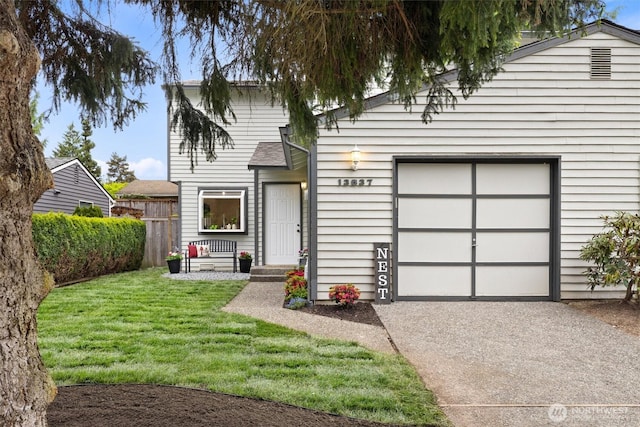 view of front facade featuring concrete driveway, a garage, fence, and a front lawn