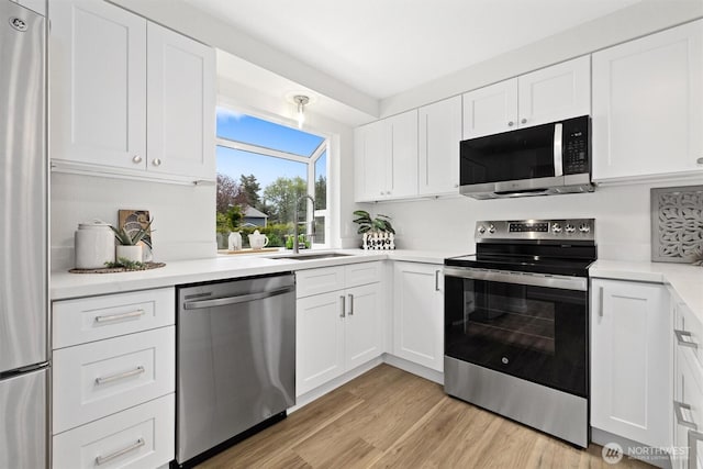 kitchen featuring a sink, white cabinetry, appliances with stainless steel finishes, and light countertops