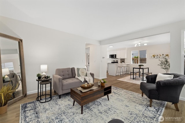 living area with baseboards and light wood-type flooring