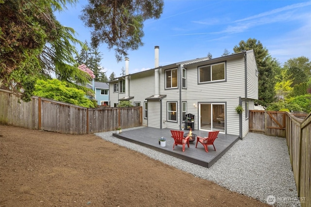 back of property featuring a fenced backyard, a wooden deck, and a gate
