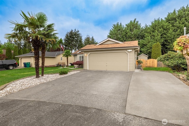 single story home featuring a garage, fence, driveway, and a front yard