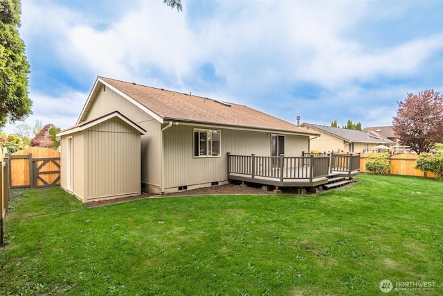 back of house with a fenced backyard, a shingled roof, a lawn, and a deck