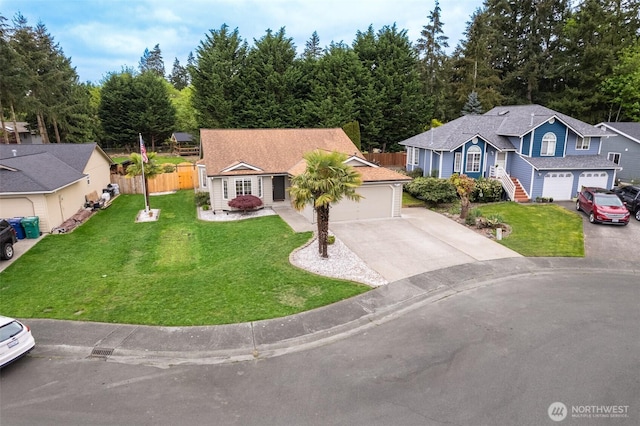 view of front facade featuring fence, driveway, and a front yard