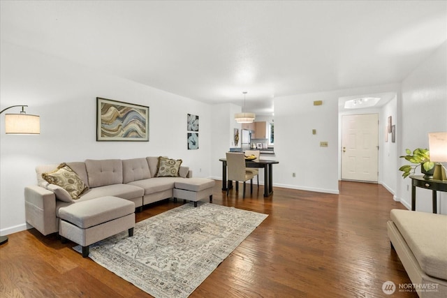 living area featuring baseboards and dark wood-style floors