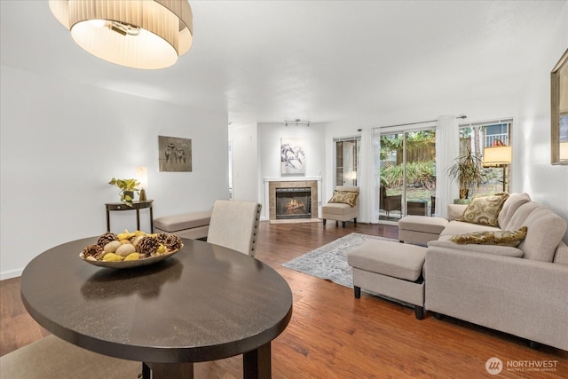 living room with a tile fireplace and wood finished floors