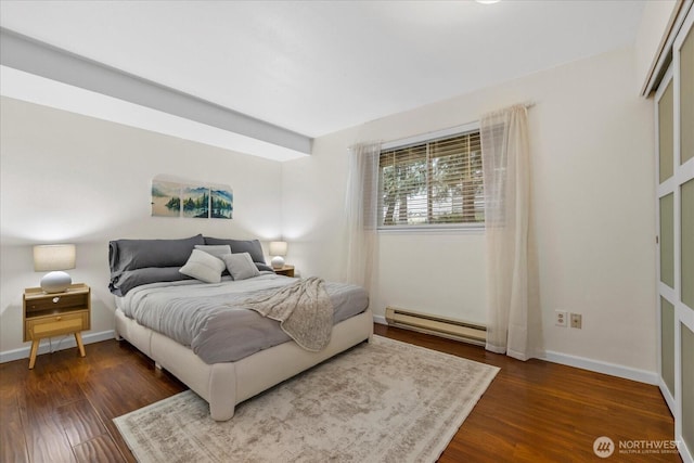 bedroom with baseboards, baseboard heating, and dark wood-type flooring