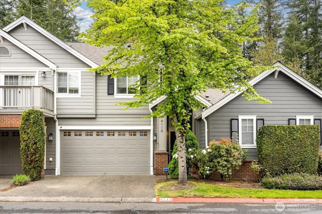 view of front of home with driveway, roof with shingles, and a garage