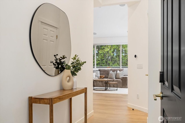 foyer entrance featuring baseboards and light wood finished floors