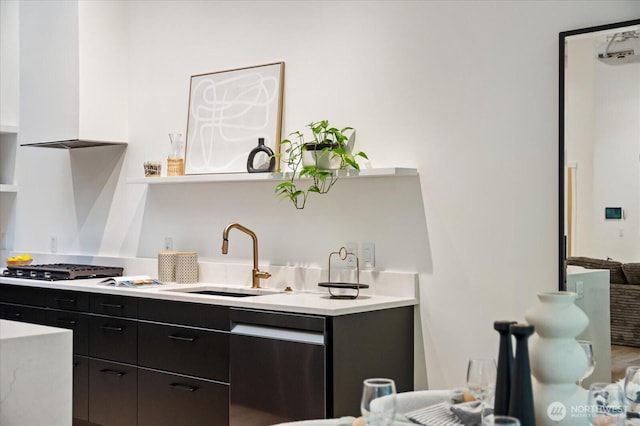 kitchen featuring open shelves, a sink, light countertops, dark cabinets, and stainless steel dishwasher
