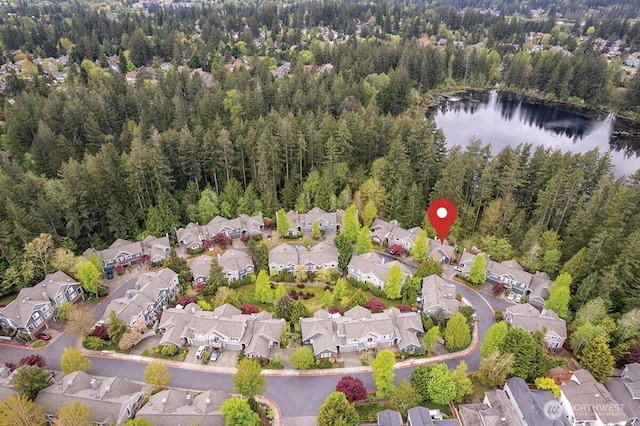 drone / aerial view featuring a water view, a residential view, and a forest view