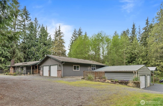 view of front facade with an attached garage, aphalt driveway, and fence