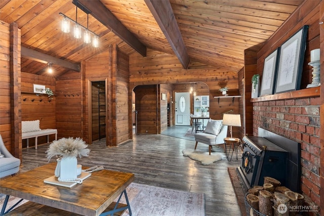 living area featuring lofted ceiling with beams, wood-type flooring, arched walkways, wood walls, and wooden ceiling