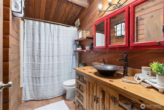 full bathroom featuring vanity, wood walls, curtained shower, toilet, and tile patterned floors