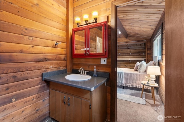 bathroom with wooden walls, vaulted ceiling, wood ceiling, and vanity
