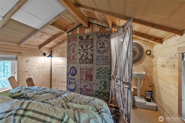 bedroom with lofted ceiling with beams, wood ceiling, wood finished floors, and wooden walls