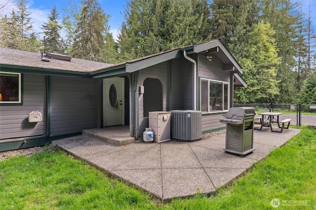 rear view of property with a patio, central air condition unit, and fence