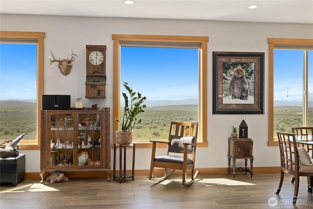 sitting room with recessed lighting, a mountain view, wood finished floors, and a wealth of natural light