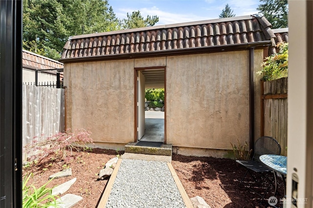 view of outbuilding featuring fence