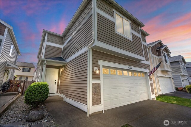 view of property featuring a garage, aphalt driveway, and fence
