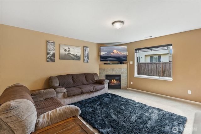living area featuring carpet floors, baseboards, visible vents, and a fireplace