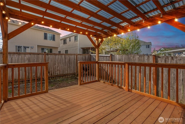 deck at dusk with a fenced backyard