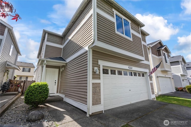 multi unit property with an attached garage, fence, and driveway