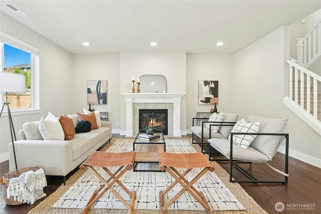 living area with visible vents, a fireplace, wood finished floors, baseboards, and recessed lighting