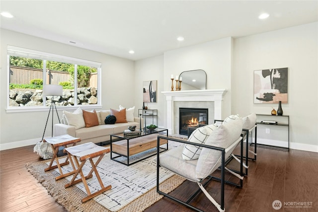 living room featuring wood-type flooring, recessed lighting, baseboards, and a glass covered fireplace