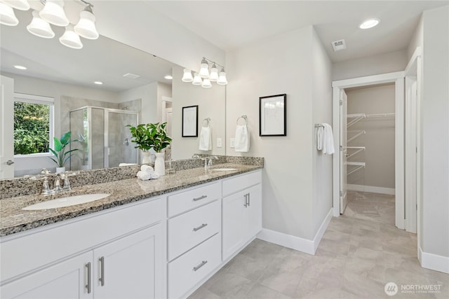 full bath with a sink, baseboards, a shower stall, and visible vents