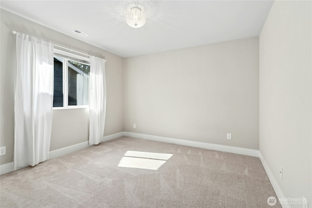 unfurnished room with carpet floors, baseboards, and visible vents