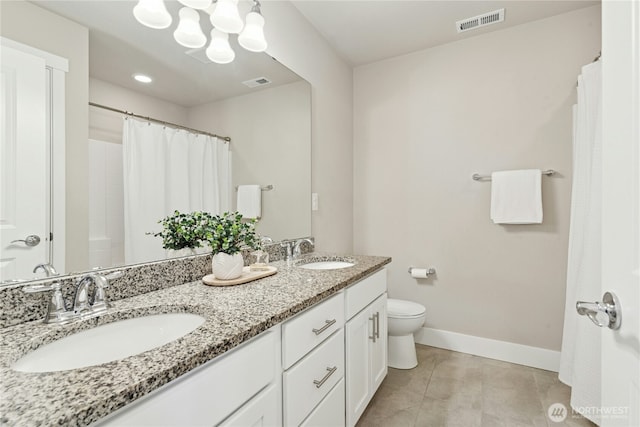 bathroom featuring visible vents, a sink, and baseboards